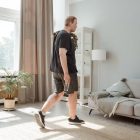 Plus size man in active wear working out in a sunny, modern living room.